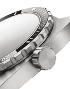 Close-up of a silver watch with a black bezel on a black background